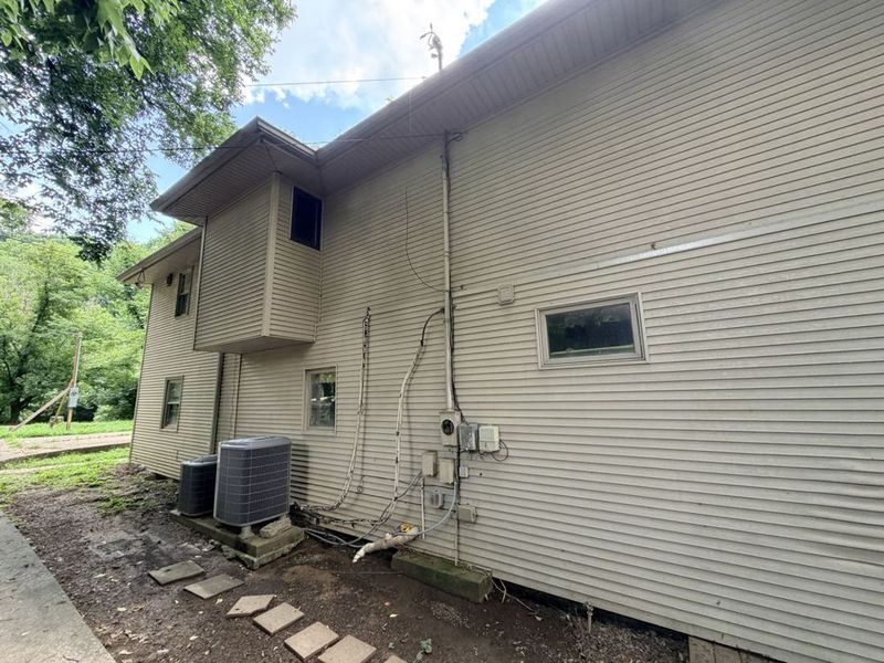 Side elevation showing the existing HVAC condenser and utility runs